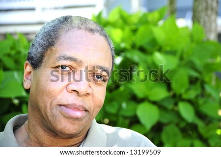 Portrait of a african american male sitting outside on his patio.