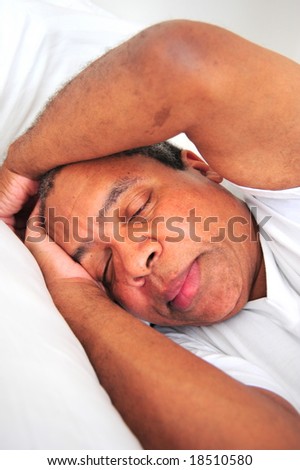 African American man sleeping in bed.