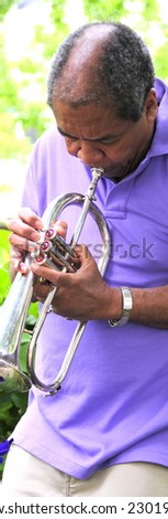African american jazz musician performing outdoors in a garden.