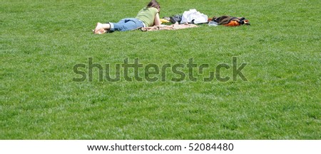 Student studying outdoors on the grass.
