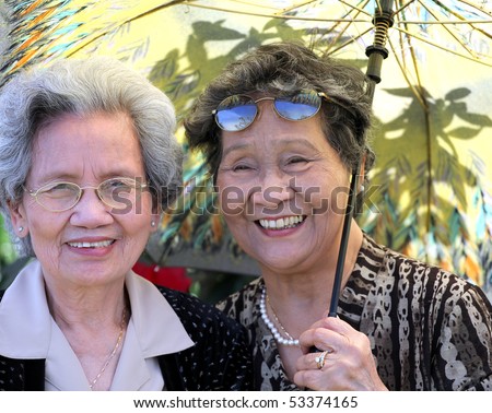 Senior asian sisters enjoying a day outside in the sun.