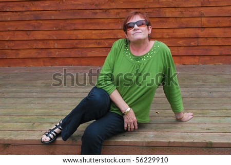 Mature female beauty relaxing on her patio deck.