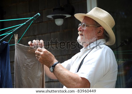 Country gentleman washing and hanging his clothes on a line outside to air dry.