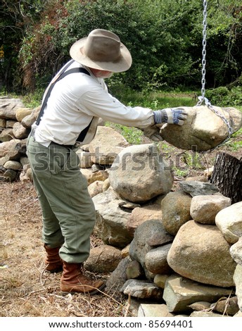 Land trust owner building a stone wall.
