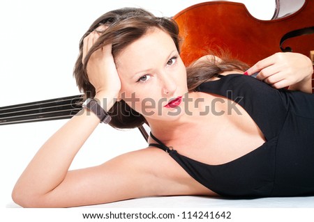 Young woman lying down in evening dress by double bass over white