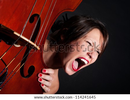 Girl face screaming by double bass closeup