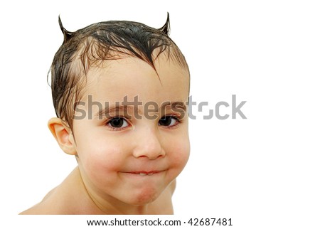 Little boy with horns made out of wet hair watching in the camera with sly smile, isolated on white