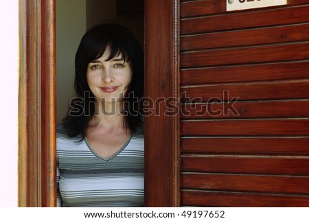 Beautiful woman welcomes at the wooden door