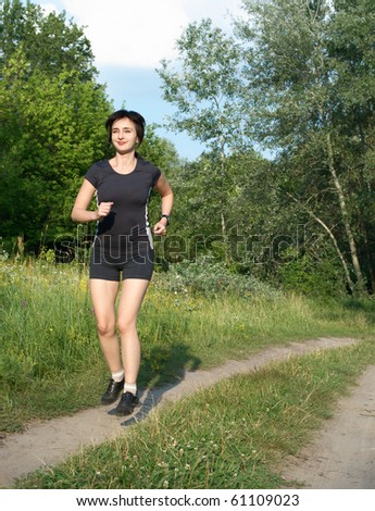 Woman jogging outdoors in summer forest