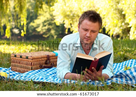 Young man reads book in the park