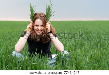 Redhead woman having fun on the green field in summer