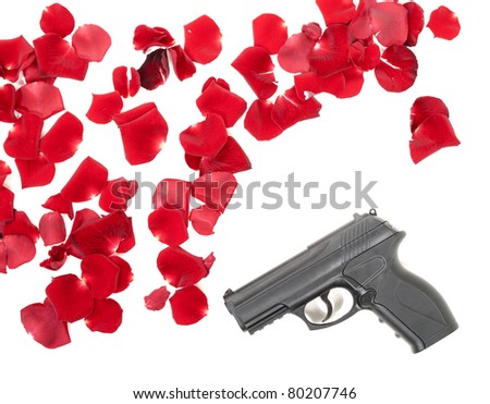 Gun between the rose petals isolated on white