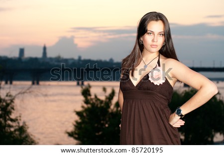 Young woman posing on the sunset panorama of Kiev background