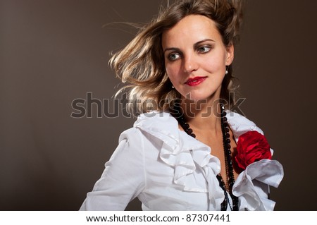 Daydreamed woman in white blouse with red flower with hair on wind
