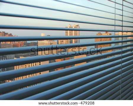 A view from a High rise window over the city of Chicago. Looking through window blinds at a view over the city.