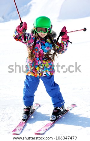 Portrait of little girl skier in sports suit finishing the ride