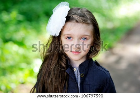 Portrait of cute little girl with white bow in her hair