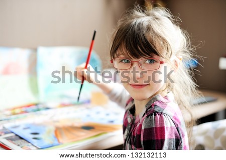 Cute little girl painting a picture in home studio