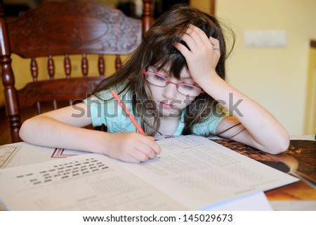 Adorable school girl doing her mathematics homework
