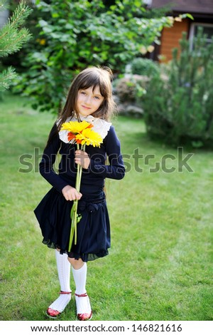 Nice young girl in navy school uniform with yellow and orange flowers