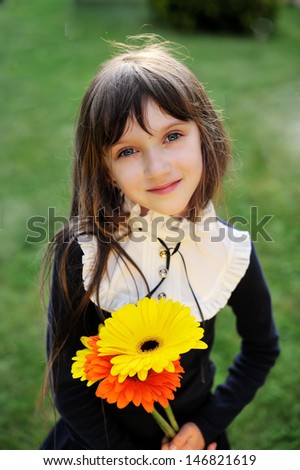 Nice young girl in navy school uniform with yellow and orange flowers