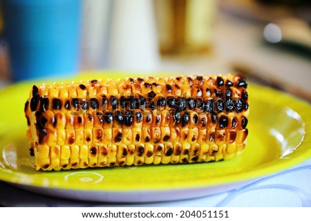 Grilled corn on the green paper plate: summer picnic