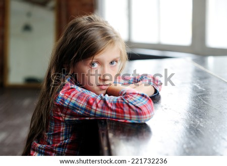 Beauty sad kid girl near the classical old piano in the retro music class