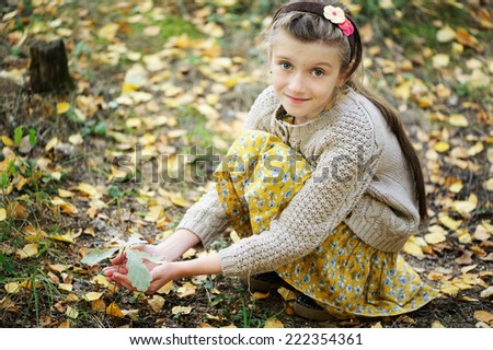 Adorable brunette kid  girl with small oak in the beauty autumn  forest l