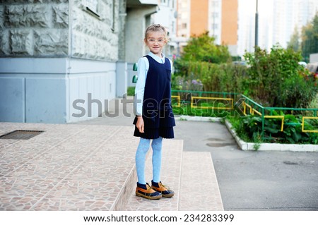 School girl in navy blue uniform on her way to school in the city