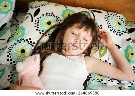Adorable little girl sleep in the bed on sunny morning