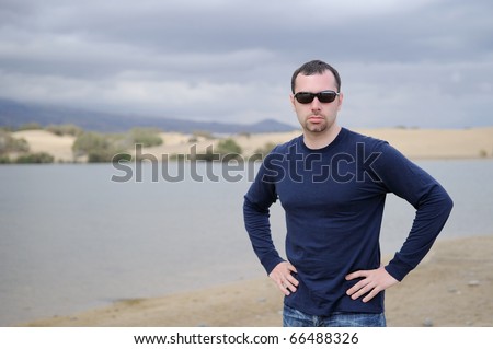 Young man on mountain lake background before storm
