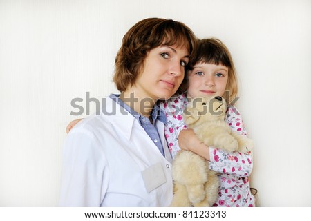 Young female doctor with a cute little patient on a white background
