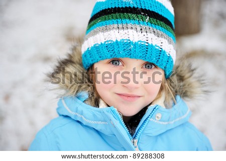 Little girl posing outdoors in winter outfit