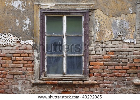 Old window with plaster and brick wall fallen in in ruins in Zagreb, Croatia.