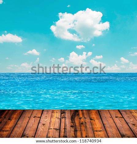 Blue ocean and sky above wooden floor