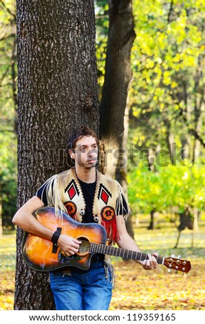 Guy playing guitar in nature