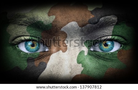 Soldier face with army colors looking from dark