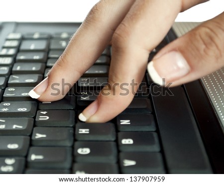Hand typing on black keyboard macro shot