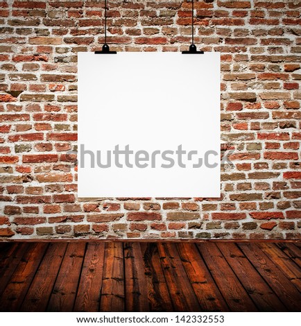 Interior of grunge empty room with empty board hanging on brick wall