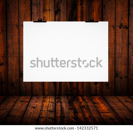 Blank paper board hanging on wooden wall