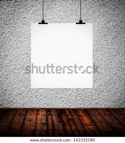 Interior of grunge empty room with white paper hanging on paper clips
