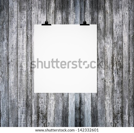 Blank paper board hanging on grunge wooden wall