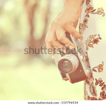 Woman hand holding retro camera close-up