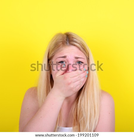 Portrait of scared girl against yellow background