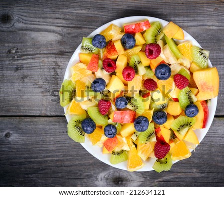 Top view of a fresh fruit salad with bananas kiwi orange blueberries and peach
