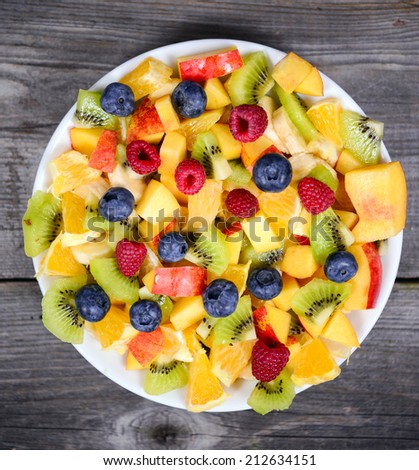 Top view of a fresh fruit salad with bananas kiwi orange blueberries and peach