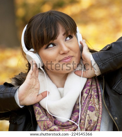 Beautiful smiling woman listening to music and dancing