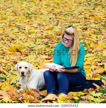 Girl with dog studying in nature