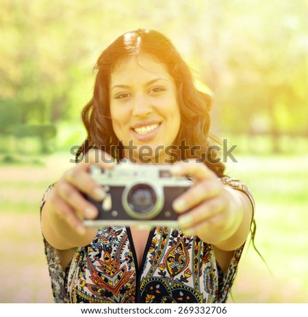 Portrait of beautiful woman taking picture mwith vintage camera