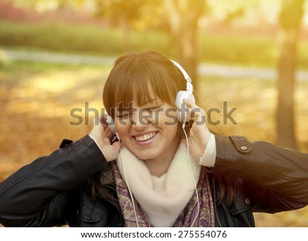 Portrait of a beautiful smiling woman listening to music and dancing